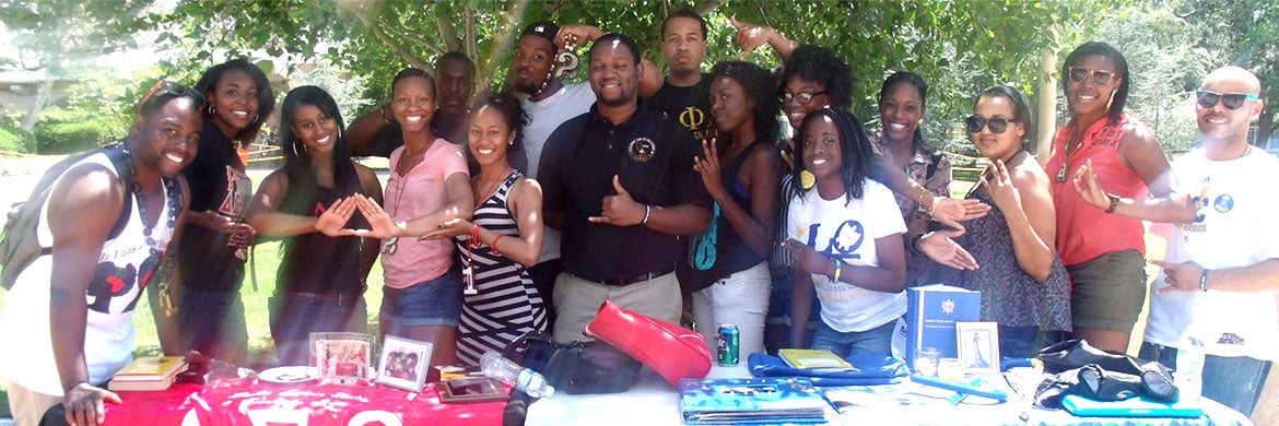 Members of organizations associated with the National Pan-Hellenic Council pose during a tabling event.