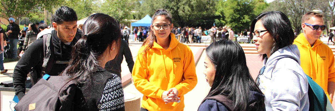 Students talk with members of a student organization during a campus tabling event.