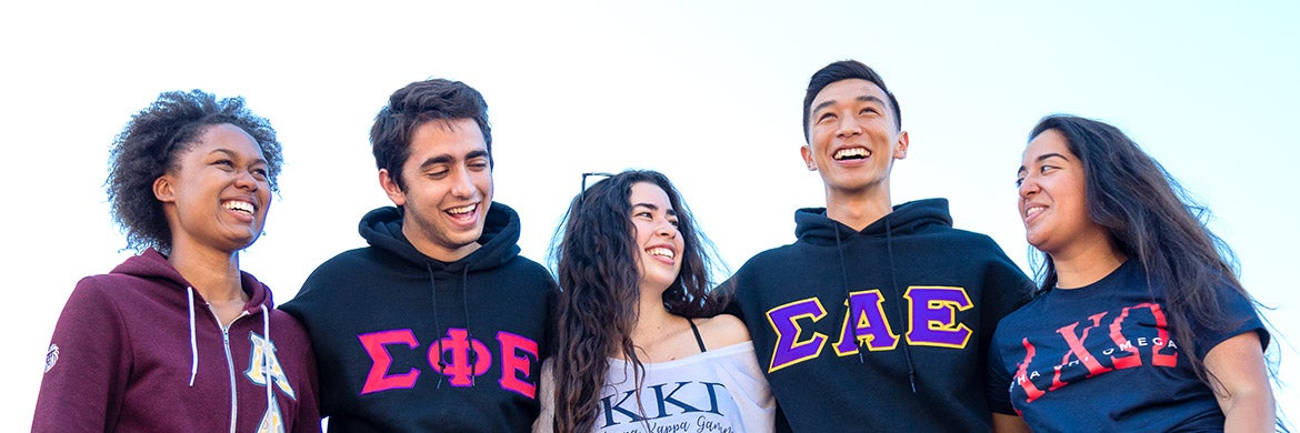 Members of fraternities and sororities pose on campus.