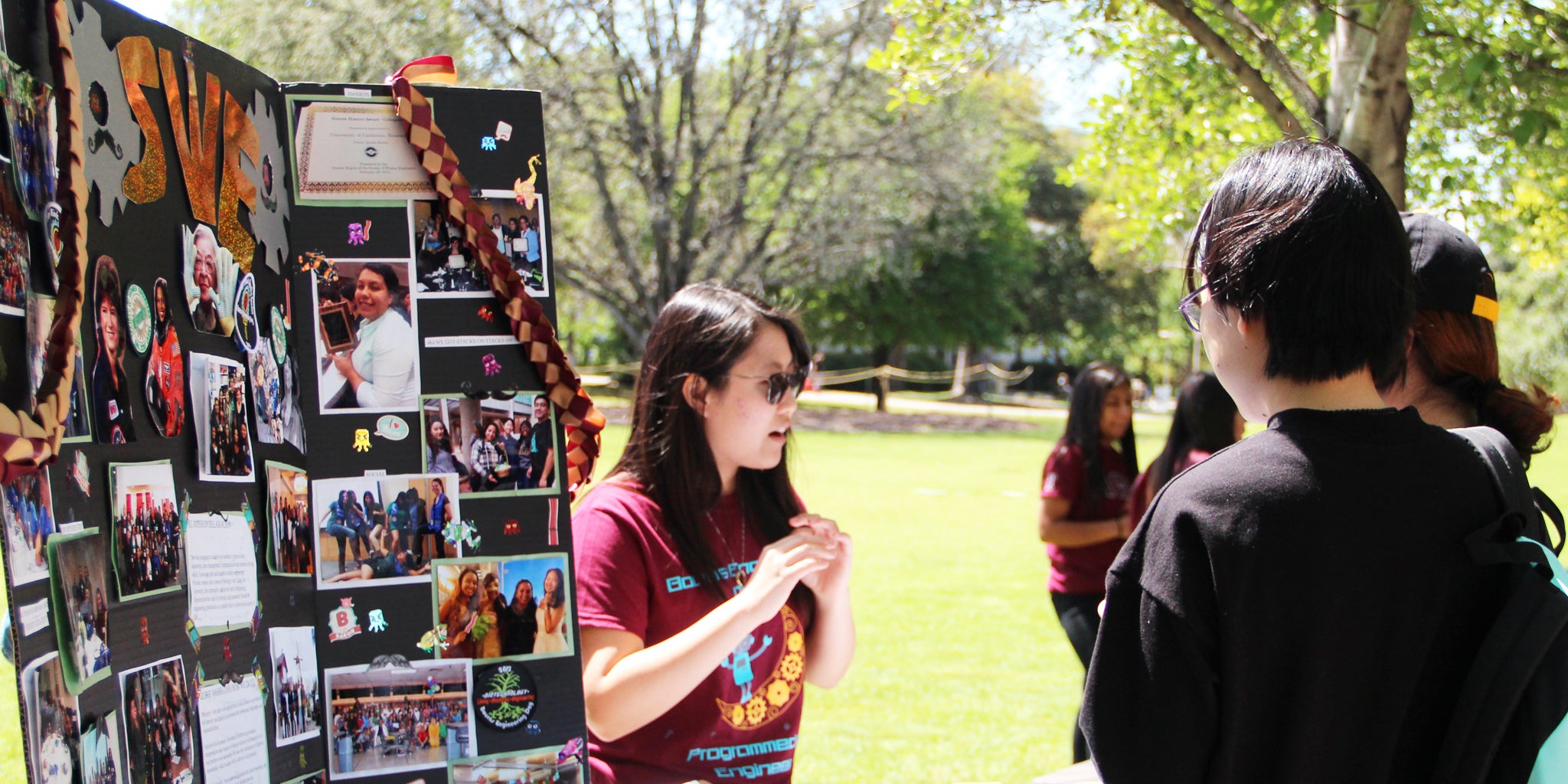 A member of a campus organization talks with students at a tabling event.