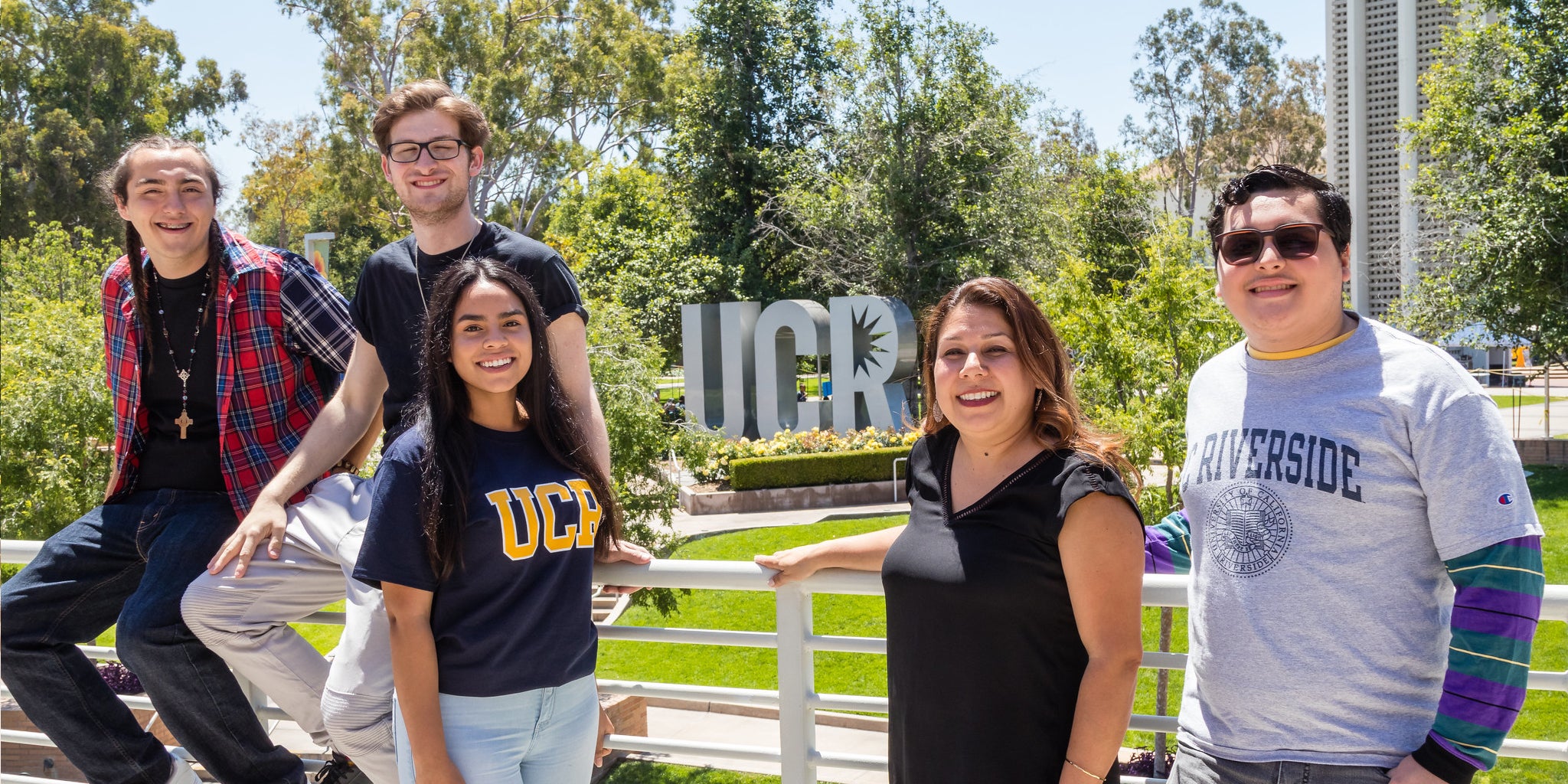 A group of UCR students pose at the Highlander Union Building in front of the UCR letter sculpture. 
