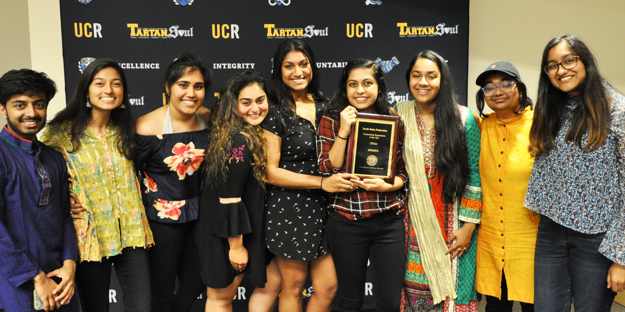 Members of a student organization pose with a service award.
