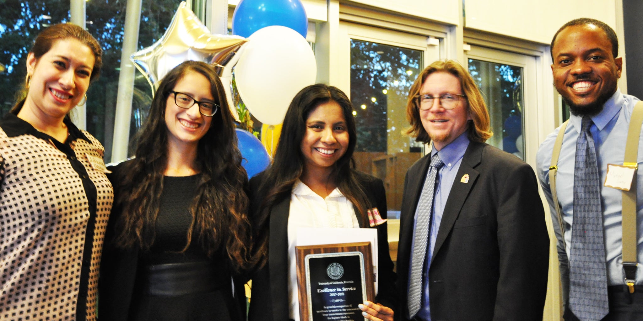 Student volunteers pose with UCR faculty and staff members during an awards ceremony.