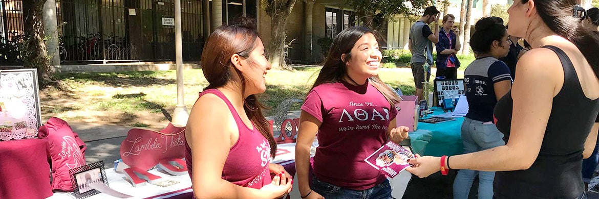 Members of a UCR sorority talk with students during a tabling event.