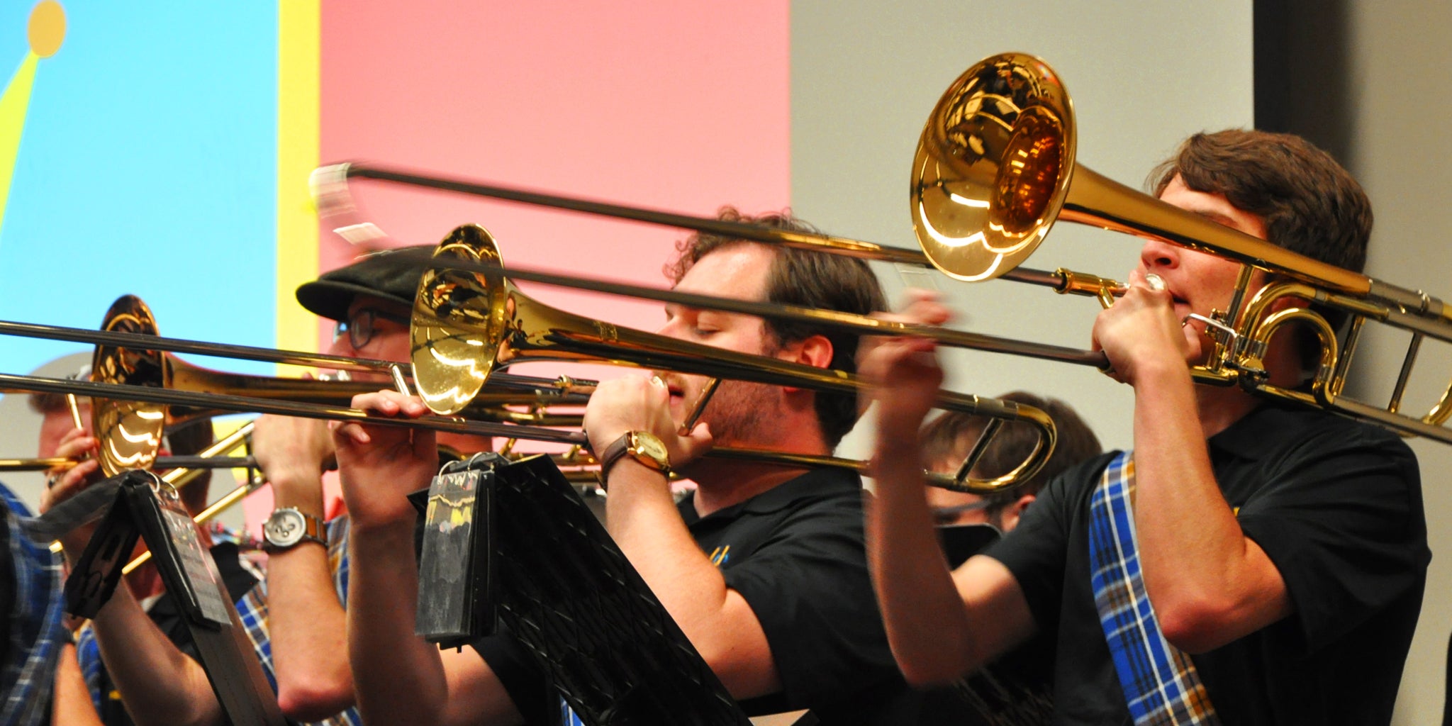 Trombone players with the Highlander Pep Band perform at an awards ceremony.